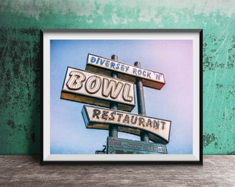 May include: A vintage neon sign for "Diversey Rock 'N Bowl Restaurant" with a blue sky in the background.