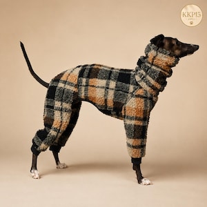 Pode incluir: Um cão a usar um fato de corpo inteiro em tecido polar com um padrão xadrez em castanho, preto e cinzento. A peça tem uma gola alta e mangas compridas que cobrem as patas, terminadas com punhos pretos. Um logótipo circular diz KKP15.