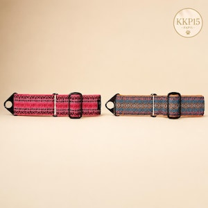 May include: Two pet collars with black hardware and D-rings. The left collar features a vibrant pink woven pattern with black accents. The right collar displays a multi-colored geometric pattern in shades of blue, orange, and brown. Text KKP15 is visible.