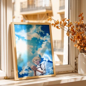Op de afbeelding: Een ingelijste verticale print met een anime-stijl illustratie van een persoon met kort blond haar in een wit overhemd met donkere banden, tegen een helderblauwe lucht vol witte wolken, weergegeven in een dunne goudkleurige lijst.