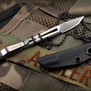 May include: A silver pocket knife with a black leather sheath and a silver chain. The knife has the word "AMSLER" engraved on the side.