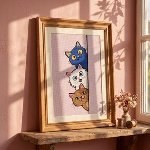 Peut inclure: Une broderie au point de croix encadrée représentant trois chats empilés verticalement, regardant derrière une ligne verticale. Le chat du haut est bleu, celui du milieu est blanc et celui du bas est marron. Le motif est sur un fond à grille rose.