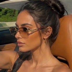 May include: Rimless sunglasses featuring a gradient brown lens that transitions from a darker shade at the top to a lighter tint at the bottom. The frames include gold-toned metal temples with intricate detailing and a bridge connecting the lenses.
