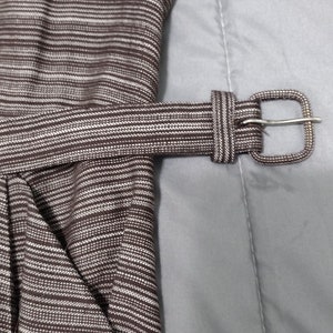May include: A brown and white striped dress with a brown fabric belt and a silver buckle.