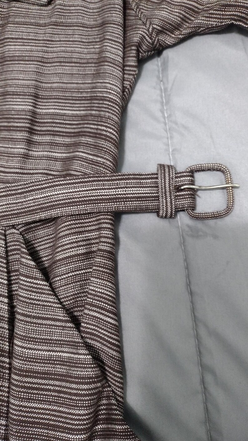 May include: A brown and white striped dress with a brown fabric belt and a silver buckle.