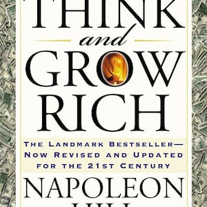 Pode incluir: A capa do livro Think and Grow Rich de Napoleon Hill apresenta um fundo branco com texto em preto. O título é proeminente, com um ícone de cifrão dourado dentro da letra O. É indicado como um best-seller revisado para o século XXI.
