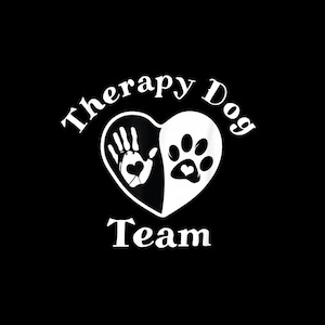May include: A black and white graphic design featuring a heart shape split into two halves. The left side shows a human handprint with a small heart in the center, and the right side shows a dog paw print with a small heart. Text reads Therapy Dog Team.