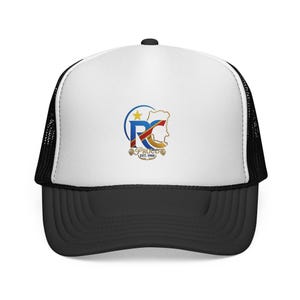 May include: A white and black trucker hat featuring a graphic on the front panel. The design includes a blue and gold logo with the letters RC, a yellow star, a map outline, and the text PROUD EST. 1960 with decorative wheat-like elements below.
