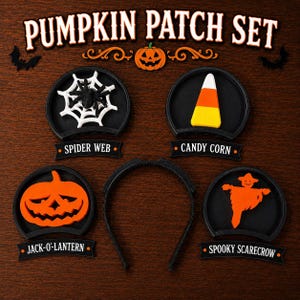 Könnte beinhalten: Ein Pumpkin Patch Set bestehend aus einem schwarzen Haarreif und vier austauschbaren runden Aufsätzen. Die Aufsätze zeigen ein weißes Spinnennetz mit einer schwarzen Spinne, einen Zuckermais, einen orangefarbenen Kürbis und eine orangefarbene Vogelscheuche.