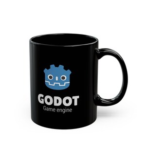 May include: A black ceramic mug featuring the blue Godot game engine logo at the top, with the white text "GODOT" in a bold sans-serif font below it, followed by the smaller white text "Game engine" centered on the front of the mug.