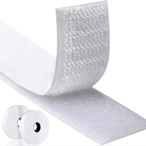 May include: A white hook and loop fastener tape strip with one end peeled back to reveal the textured plastic hook surface. Two circular rolls of the same white adhesive fastener tape are positioned in the lower left corner of the frame.