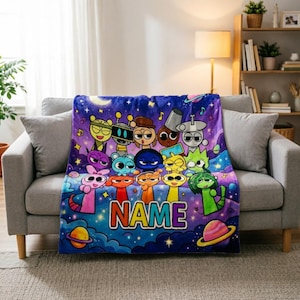 Könnte beinhalten: Eine weiche Plüschdecke mit einem lebendigen, violett-blauen Weltraumhintergrund, verziert mit verschiedenen bunten Zeichentrickfiguren, Planeten und Sternen. Das Wort NAME ist in großen, mehrfarbigen Blockbuchstaben unten mittig aufgedruckt.
