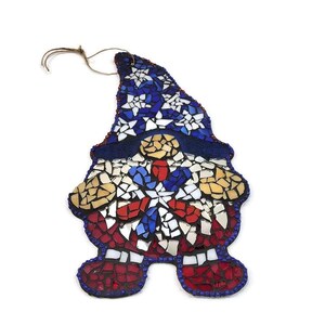 May include: A mosaic gnome ornament with a red, white, and blue design. The gnome is wearing a hat with stars and has a beard made of mosaic tiles.