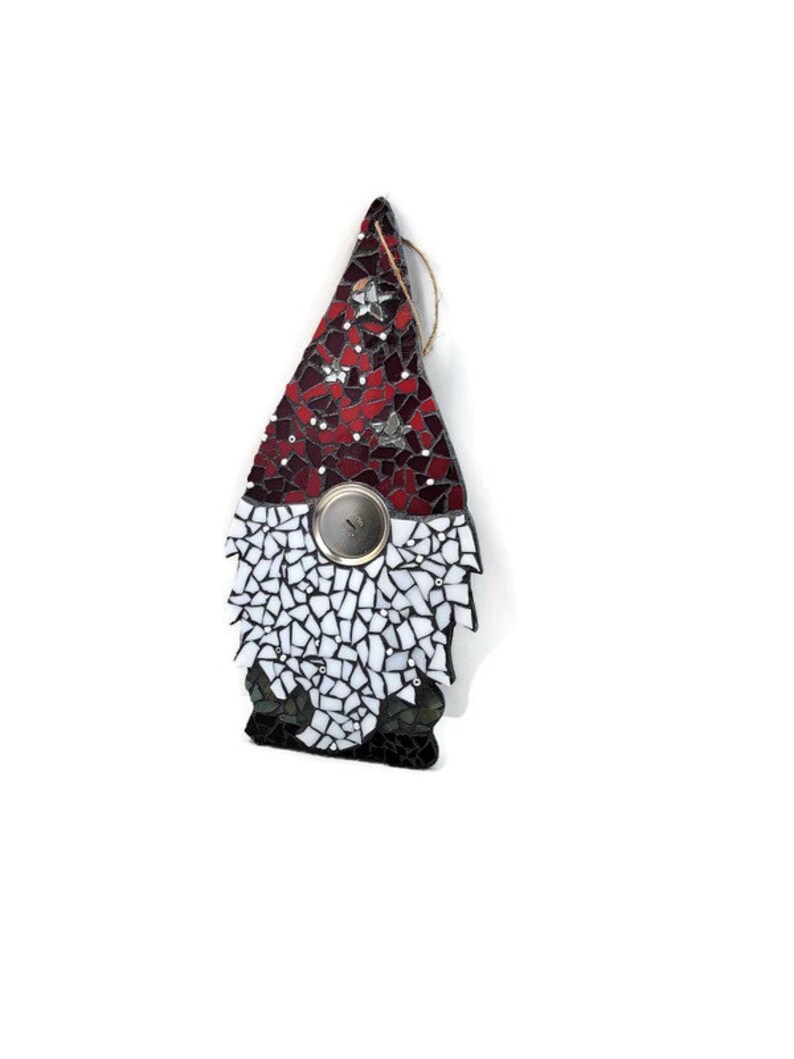 Op de afbeelding: Een moza&iuml;ek kabouter ornament met een rode en witte hoed, een zilveren knoop en een jute touwtje om op te hangen. De hoed heeft stervormige accenten. De baard van de kabouter is wit en de basis is zwart.