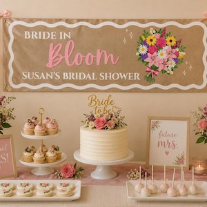 May include: A rectangular banner with a scalloped white border on a tan background, featuring the text "BRIDE IN Bloom" and "SUSAN'S BRIDAL SHOWER" in pink and white, accompanied by a colorful floral bouquet illustration and small star accents.