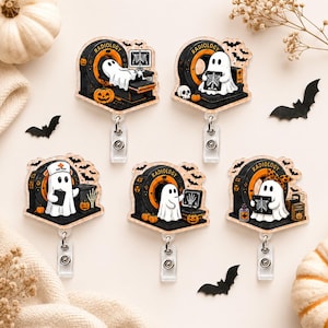 May include: Five acrylic badge reels featuring white ghost characters in a radiology setting. Each design includes a black CT scanner with the word RADIOLOGY, orange pumpkins, and bats. The ghosts are shown interacting with medical equipment.