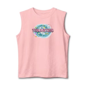 May include: A light pink sleeveless shirt featuring a central graphic of a blue swirling galaxy with the word TRAUMATIZED printed in pink letters. The design includes small colorful planets, stars, and orbital lines surrounding the text.