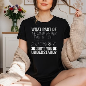 May include: A black short-sleeved t-shirt featuring a white graphic print of an electronic circuit diagram. The text "WHAT PART OF" is printed above the diagram, and "DON'T YOU UNDERSTAND?" is printed below the diagram in a distressed white font.