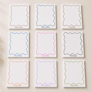 May include: Nine rectangular white notepads arranged in a grid, each featuring a unique colored wavy border and a personalized name printed at the bottom. The border colors include red, dark blue, brown, blue, pink, black, orange, purple, and green.
