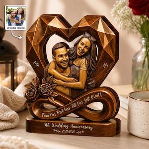 Peut inclure: Une sculpture en bois en forme de cœur avec un couple sculpté, deux roses et le texte "John", "Lily", "From Our First Kiss Till Our Last Breath" et "5th Wedding Anniversary 2021-2026". L'objet présente un cadre géométrique à facettes.