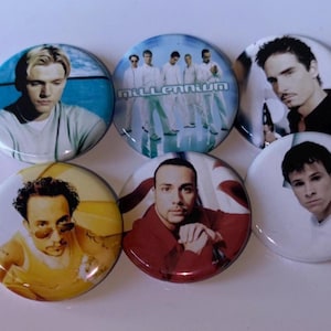 May include: Six circular pinback badges featuring photographic portraits of the members of the boy band Backstreet Boys. One badge displays the group standing together with the text Millennium, while the others show individual members.