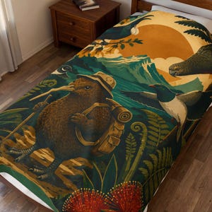 May include: A plush blanket featuring a vibrant illustration of a kiwi bird wearing a hat and carrying a backpack with a walking stick. The scene includes a large orange sun, green mountains, ferns, red pohutukawa flowers, and other native birds.