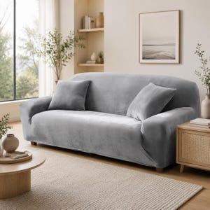 May include: A light gray velvet sofa cover featuring a smooth, solid-colored fabric texture that fits snugly over the furniture. The cover includes two matching square throw pillows placed on the seat, providing a uniform look across the entire sofa.