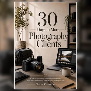 May include: A book titled 30 Days to More Photography Clients by Shane Cranston, featuring a black camera, a laptop displaying photo editing software, a coffee mug, and a notebook on a desk, with a potted plant and shelving in the background.