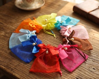 Simpatici sacchettini per caramelle con fiocco di perle – 10 colori. Confezioni piccole per dolcetti, ideali come regali per feste e bomboniere.
