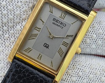 Vintage Seiko Quarz Tank Grau Zifferblatt Gold-Ton-rechteckige Gehäuse-Schwarz-Leder-Armband-Uhr