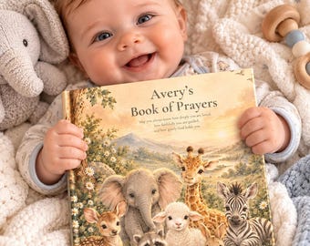 Op de afbeelding: Een hardcover boek getiteld Avery's Book of Prayers met een illustratie van een hert, olifant, wasbeer, lam, giraf en zebra op de kaft. De tekst op de omslag luidt: May you always know how deeply you are loved.