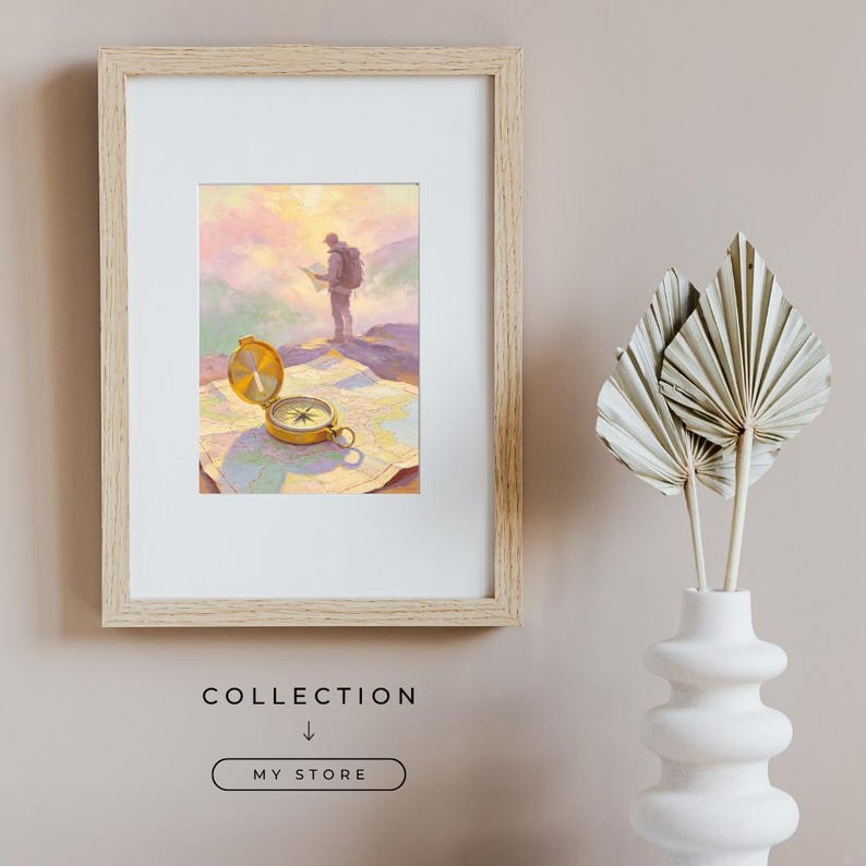 May include: A framed print featuring a hiker standing on a mountain peak at sunset, with a gold compass resting on an open map in the foreground. The frame is light wood, and the artwork displays soft pastel colors of pink, yellow, and blue.