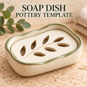 Puede incluir: Una jabonera rectangular de cerámica con acabado crema moteado y borde teñido de verde. El interior cuenta con una pieza extraíble con un patrón recortado en forma de hoja para el drenaje. El texto SOAP DISH POTTERY TEMPLATE es visible arriba.