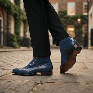 Person walking in blue leather spat-style boots on a cobblestone European street