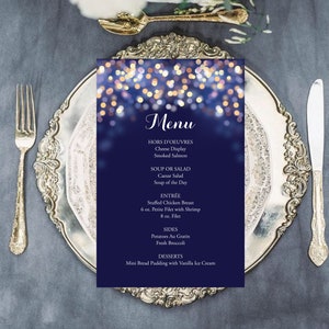 May include: A blue menu card with a sparkling lights background. The menu includes hors d'oeuvres, soup or salad, entree, sides, and desserts. The entree options are stuffed chicken breast, 6 oz. petite filet with shrimp, and 8 oz. filet. The sides are potatoes au gratin and fresh broccoli. The dessert is mini bread pudding with vanilla ice cream.