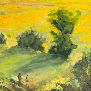 Detail of Dawn Chandler’s original New Mexico landscape painting Abiquiu Field of Summer Gold, centering on sunlit trees and bushes casting long shadows across warm green grass, with loose, painterly marks suggesting the yellow field beyond.