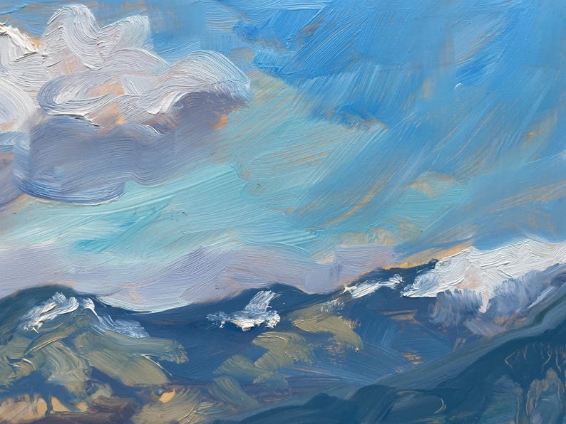Close-up of original New Mexico landscape painting Spring Morning Over the Taos Mountains by Santa Fe artist Dawn Chandler, emphasizing the luminous sky and snow-capped Taos mountains, with sweeping blue and aqua brushstrokes, touches of peach and lavender light near the horizon, and creamy white clouds hovering above deep indigo ridges, showcasing the loose, expressive oil paint handling and atmospheric spring morning light.