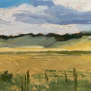 Close‑up detail of original New Mexico landscape oil painting Under a High Country August Sky by Santa Fe artist Dawn Chandler, focusing on the foreground meadow with textured impasto strokes of ochre and olive greens, delicate vertical grasses, and distant soft green hills beneath bands of pale clouds and blue sky, emphasizing the tactile surface of the oil on panel.