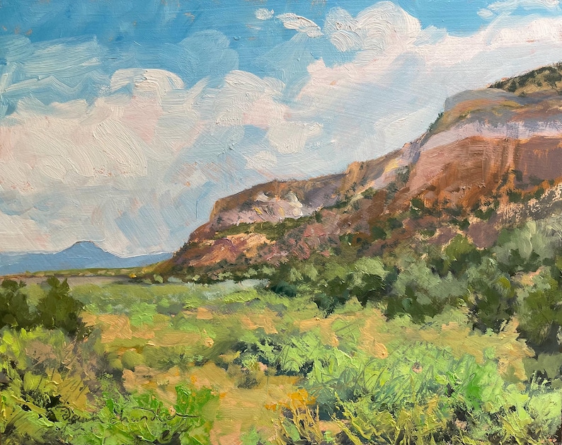 Original New Mexico landscape oil painting “Finding My Way to Pedernal” by Santa Fe artist Dawn Chandler, featuring Pedernal’s blue silhouette beyond sunlit Abiquiu mesas, sweeping green valley grasses, distant cottonwoods and expressive clouds painted with lively, textured brushstrokes; an atmospheric Southwest scene by contemporary landscape painter Dawn Chandler.