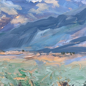 Detail from original New Mexico landscape painting Spring Morning Over the Taos Mountains by Santa Fe artist Dawn Chandler, highlighting the rolling mid-distance slopes painted in layered blues, olives, and warm umbers, with a narrow band of sunlit fields and tiny tree marks at the base of the mountains, all above thick, swirling strokes of green foreground grasses that convey movement and depth in the Taos valley.