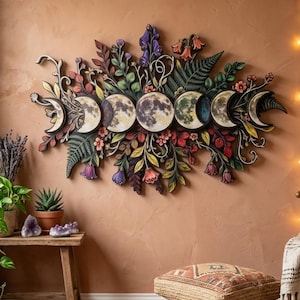 May include: A horizontal wall hanging featuring a series of moon phases depicted in circular wooden panels, surrounded by intricate, multi-colored carved foliage, flowers, and fern leaves in shades of green, purple, red, and yellow.