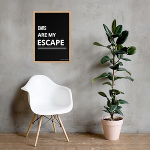 May include: A rectangular wall art print in a light wood frame featuring a black background with white text that reads CARS ARE MY ESCAPE above a horizontal white line. The print includes the small text FUEL & STYLE at the bottom right corner.