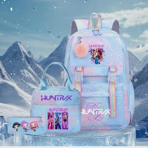 May include: A light blue backpack, lunch bag, and pencil case set featuring a pastel gradient, snowflake patterns, and the text "HUNTRAX". The backpack includes a pink pom-pom charm, rainbow straps, and a graphic of three characters.