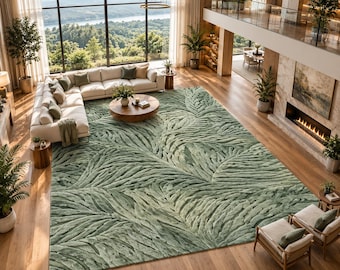 Puede incluir: Una alfombra rectangular grande con un patrón de hojas en relieve texturizado en un color verde salvia suave. La alfombra cubre una parte importante del suelo de madera en una sala de estar, mostrando un diseño botánico repetitivo con surcos profundos.