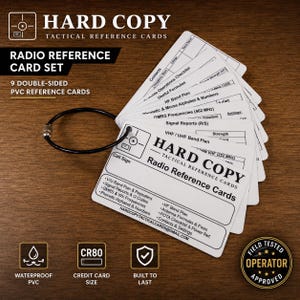 May include: A set of nine double-sided white PVC radio reference cards held together by a black metal ring. The cards feature black printed text including Hard Copy Tactical Reference Cards, frequency charts, signal reports, and phonetic alphabets.