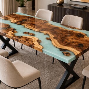 May include: A rectangular dining table featuring a live edge wood slab with a prominent natural grain and burl pattern, bisected by a smooth, translucent light blue resin river. The table is supported by a black metal X-shaped base and six chairs.