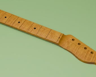 May include: A light brown wooden guitar neck featuring a prominent flame maple grain pattern. The neck includes a fretboard with dark circular fret markers and a headstock with six pre-drilled holes for tuning pegs, showcasing a natural wood finish.