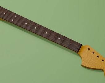 May include: A guitar neck featuring a dark brown scalloped fretboard with white circular position markers and a light tan wooden headstock with six pre-drilled holes for tuning pegs. The neck has a smooth finish and a distinct curved headstock shape.
