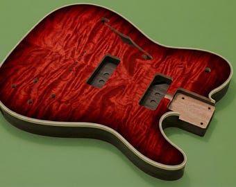 May include: An unfinished electric guitar body featuring a deep red flame maple top with a glossy finish. The body includes a single f-hole, two rectangular pickup cavities, a neck pocket, and pre-drilled holes for bridge and control components.