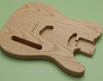May include: An unfinished light brown wooden electric guitar body with a visible natural wood grain pattern. The body features pre-cut cavities for pickups, a bridge, and a neck pocket, along with small pre-drilled holes for hardware mounting.